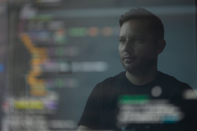 Developer reading lines of code in a mirror image of his monitor Developer reading lines of code in a mirror image of his monitor