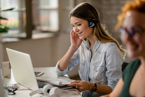 woman working on a computer speaking into a headset