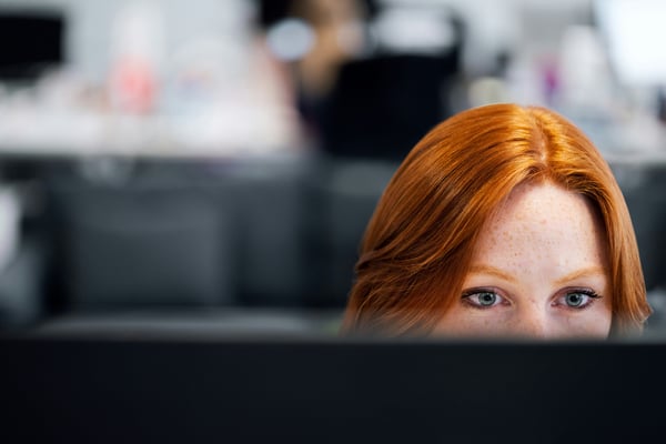 woman with red hair working on a computer. woman with red hair working on a computer.