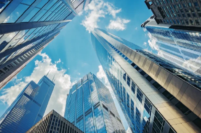 A candid cinematic shot of three diverse sharpdressed executives two women one man laughing while looking at a large wallmounted touch screen displayi-Dec-10-2025-06-16-56-6746-AM