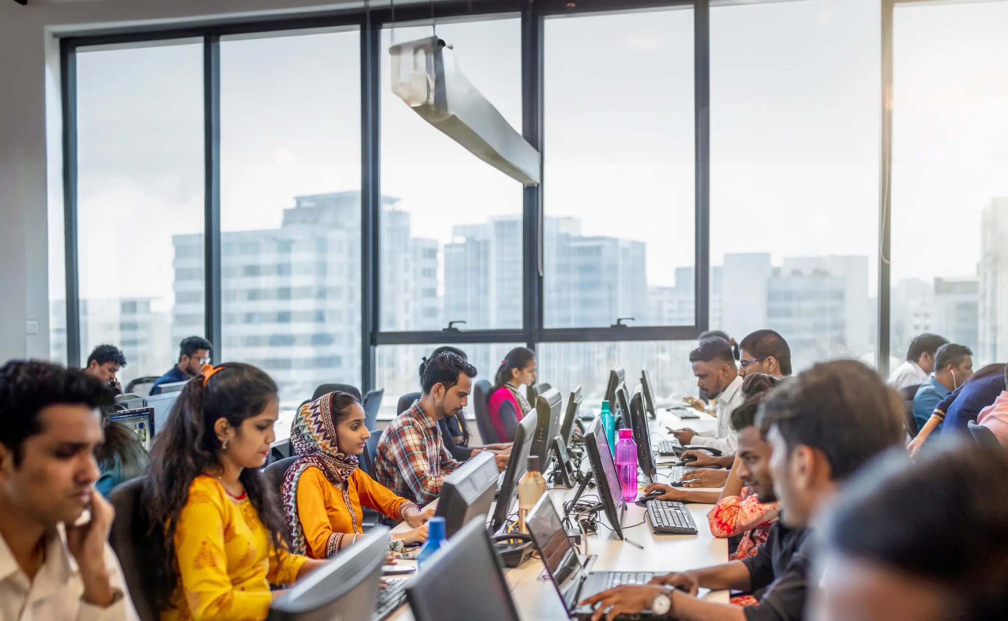 Multi-Country BPO Team working on computers in a high-rise office.  