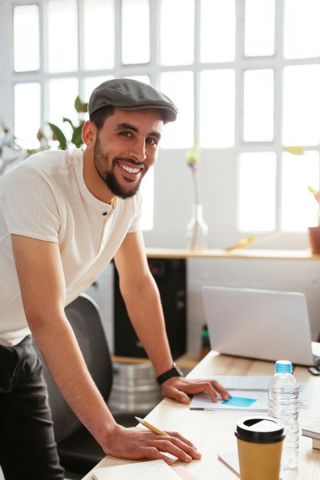 portrait-of-smiling-young-man-taking-notes-at-desk-2024-09-23-07-14-10-utc