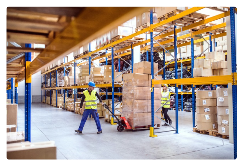 Two warehouse workers pulling a pallet loaded with boxes. Two warehouse workers pulling a pallet loaded with boxes.