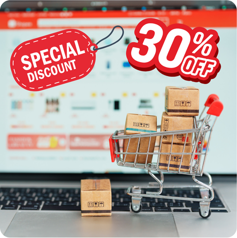 Miniature shopping cart boxes in it in front of a laptop.